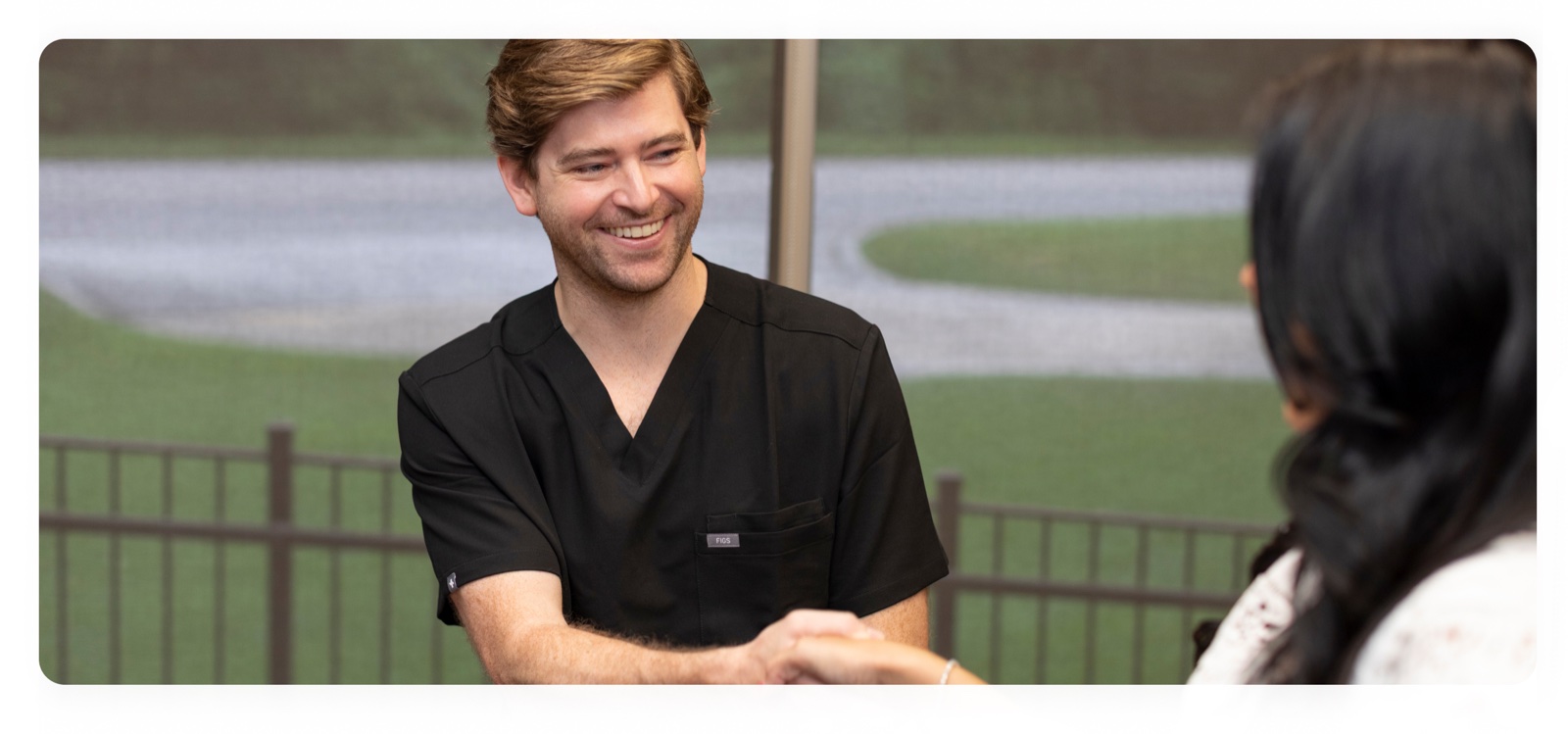 Dr. Cameron Walsh welcomes a patient with a smile and handshake